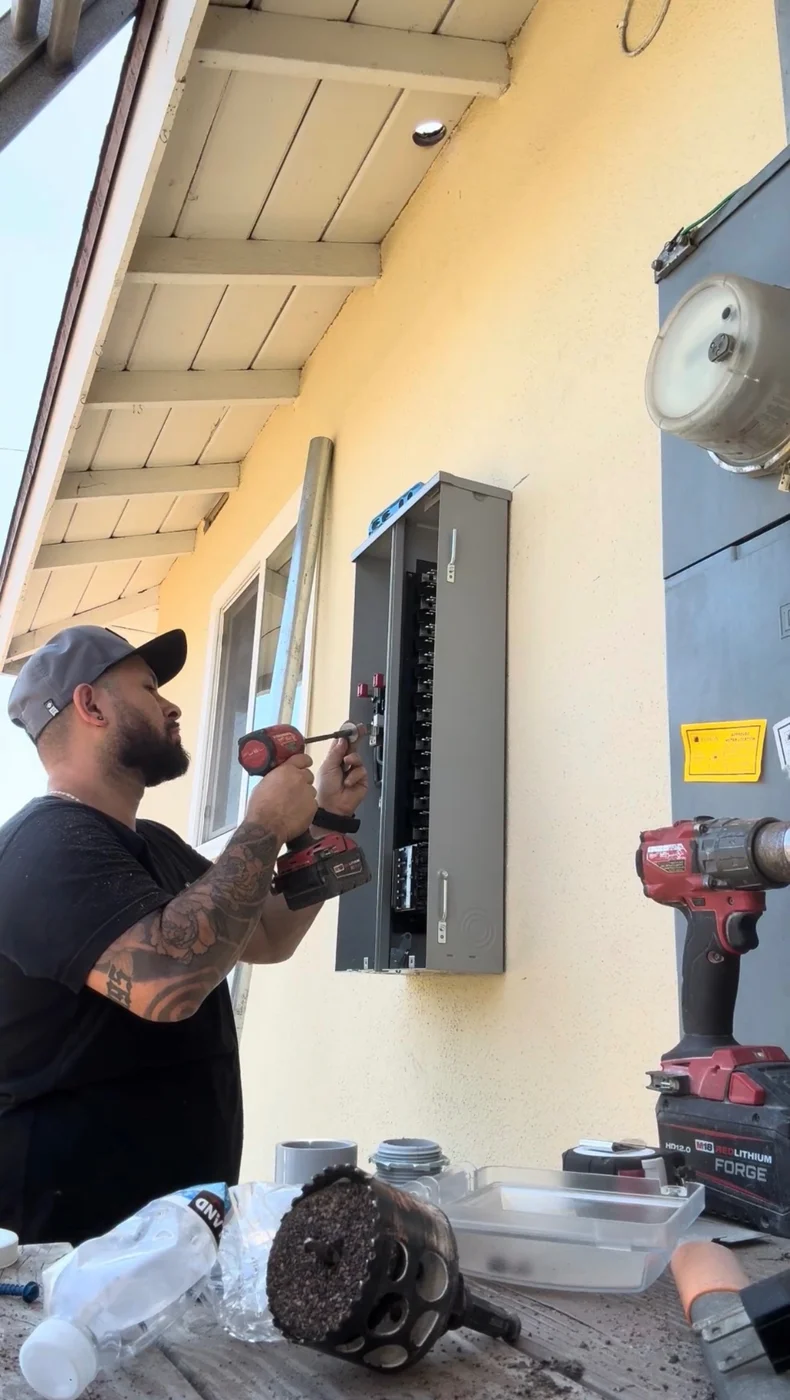 Roy Camarena of J&R Electric installing an exterior electrical panel