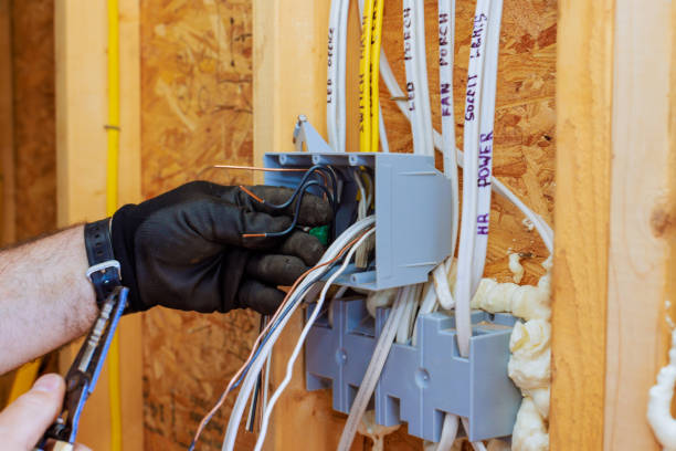 Electrician working on electrical wiring and junction boxes during a home remodel