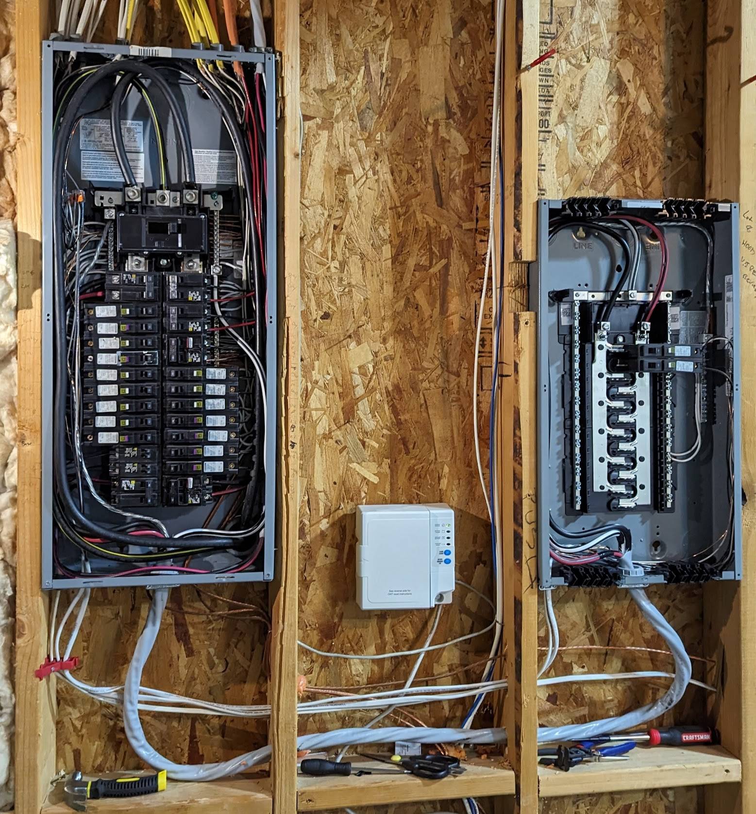 Professional installation of two electrical sub-panels side-by-side on wood framing